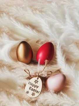 Decorative Easter eggs with Happy Easter tag resting on soft pampas grass, .. Photos