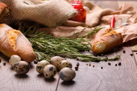 Decorative easter eggs with herbs and flowers on table Stock Photos