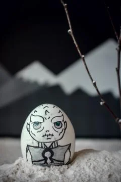 Decorative Easter eggs in snow with mountains background. DIY concept. Stock Photos