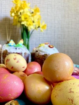 Decorative Easter eggs in various pastel shades are arranged in front of two Stock Photos