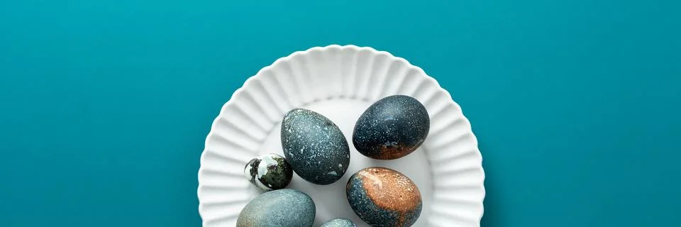 Decorative Easter eggs with various textures and colors are arranged neatly o Stock Photos