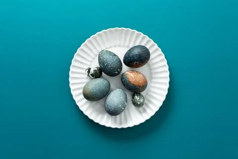 Decorative Easter eggs with various textures and colors are arranged neatly o Stock Photos