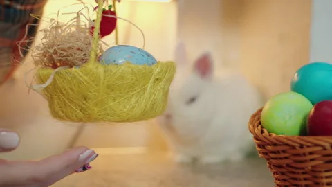 Decorative Easter scene. Yellow nest basket with blue decorative egg rotates Video stock 330497591