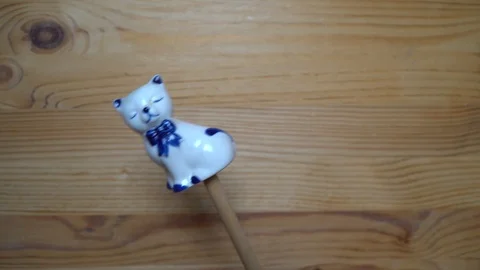 Decorative element - ceramic shape of cat moving on wooden background Stock Footage 93074106