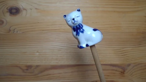 Decorative element - ceramic shape of cat moving on wooden background Stock Footage 93074424