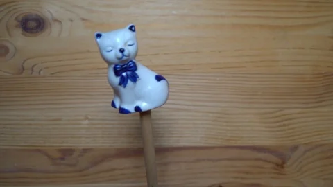 Decorative element - ceramic shape of cat moving on wooden background Stock Footage 93074739