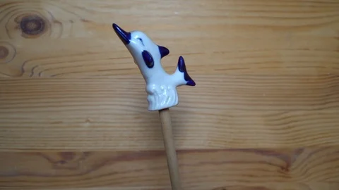 Decorative element - ceramic shape of dolphin moving on wooden background Stock Footage 93073861