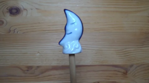 Decorative element - ceramic shape of moon moving on wooden background Stock Footage 93071621