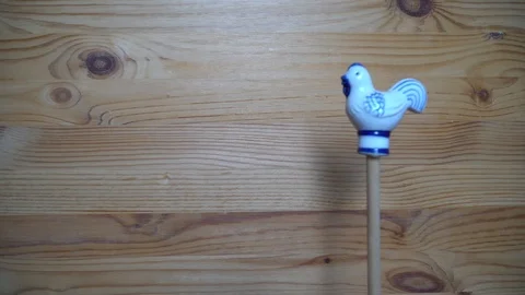 Decorative element - ceramic shape of rooster moving on wooden background Stock Footage 93070520