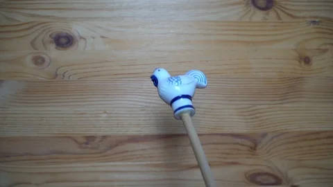 Decorative element - ceramic shape of rooster moving on wooden background Stock Footage 93071182