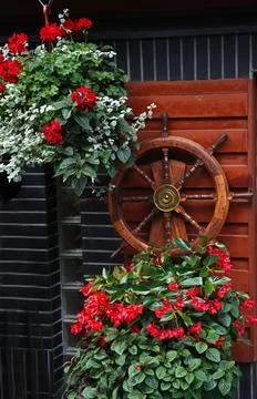 Decorative element in the form of a steering wheel against a red wall, deco.. Stock Photos