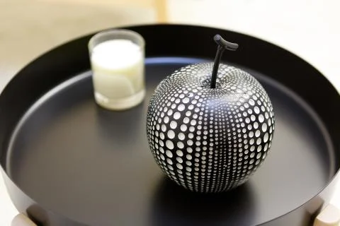 A decorative element in the shape of an apple on the table. Black and round t Stock Photos