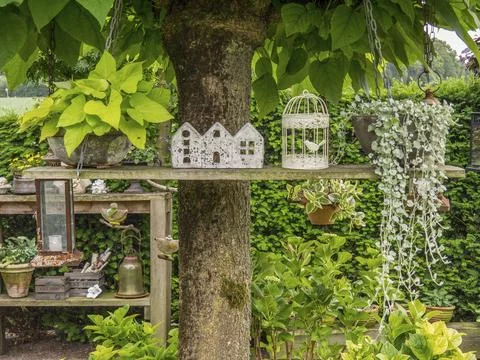 Decorative elements on a shelf attached to a tree in a green garden, borken, Stock Photos