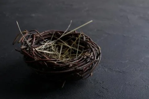 Decorative empty willow birds nest on dark rusty background. Copyspace Stock Photos