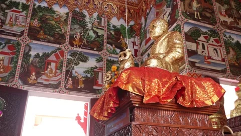 Decorative fabric flutters below a seated Buddha in a Buddhist temple Stock Footage 269294828