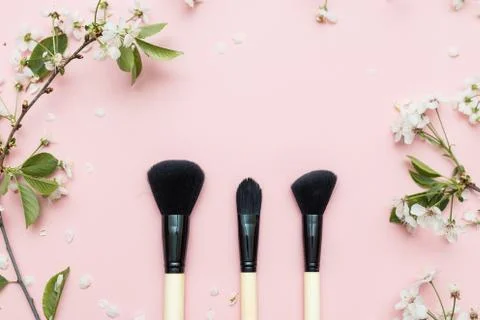 Decorative flat lay composition with cosmetics brushes and flowers. Flat lay Stock Photos