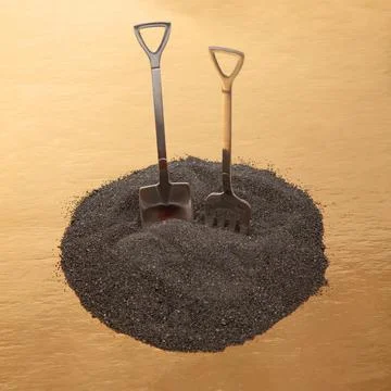 Decorative fork and spoons in the form of shovels on black sand. food tools. Stock Photos