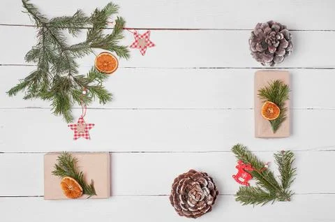 Decorative frame from gift boxes, pine cones, orange slices and fir branches  Stock Photos