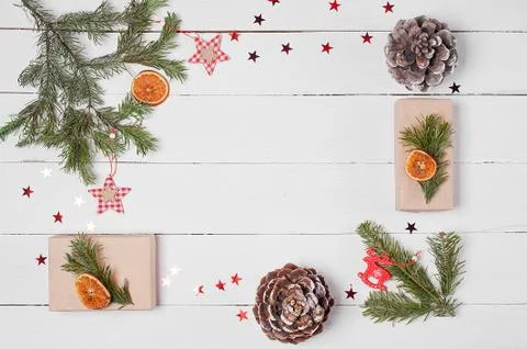 Decorative frame from gift boxes, pine cones, orange slices and fir branches  Stock Photos