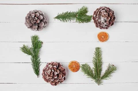 Decorative frame from pine cones, orange slices, cotton and fir branches. Stock Photos