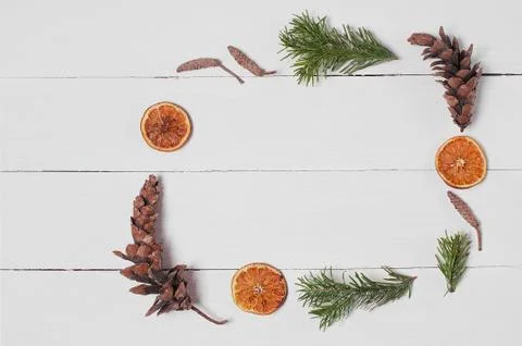 Decorative frame from pine cones, orange slices, cotton and fir branches. Stock Photos