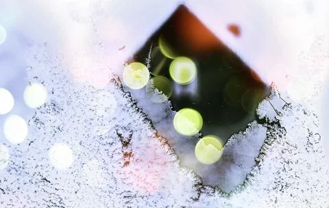 Decorative frost forms intricate patterns on glass, contrasting with soft, co 写真素材