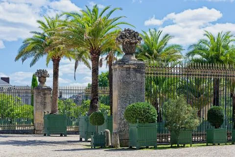 Decorative gate and palm trees near the Versailles gardens in France Stock Photos