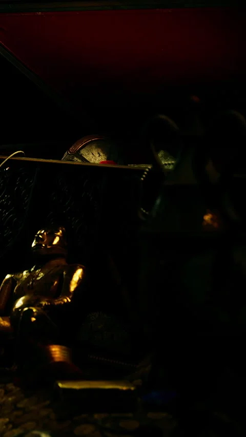 Decorative gold figure resting on a table with various objects around it Stock Footage 337960484