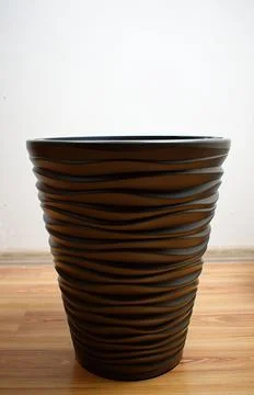 Decorative gray empty flowerpot on a white wall background. Plant transplant  Stock Photos
