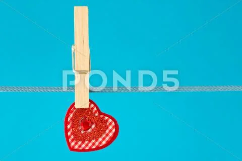 Decorative heart hung on clothesline Stock Photos