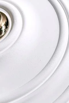 Decorative item made of white plaster on ceiling close-up. Relief stucco in.. Stock Photos