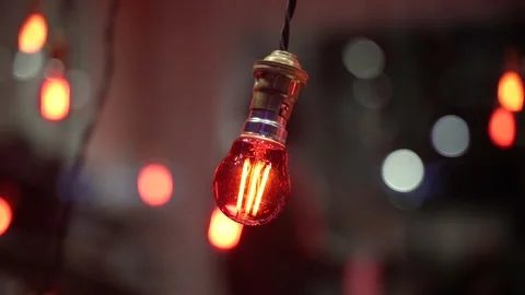 Decorative light bulbs with warm glow in evening atmosphere with bokeh backgr Stock Footage 335500610