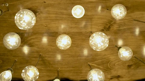 Decorative lighting bulbs hanging on ceiling. Bright glowing light from vintage Stock Footage 101770502