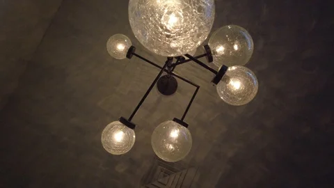 Decorative lighting bulbs hanging on ceiling. Bright glowing light from vintage  Stock Footage 102399206