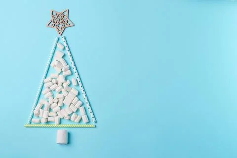 Decorative marshmallow tree on blue background from above. Christmas concep.. Stock Photos