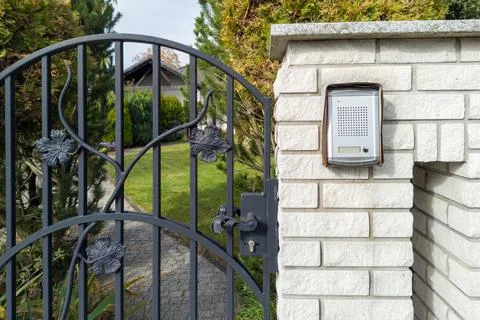 Decorative Metal Gate with Intercom and Brick Wall Foto stock