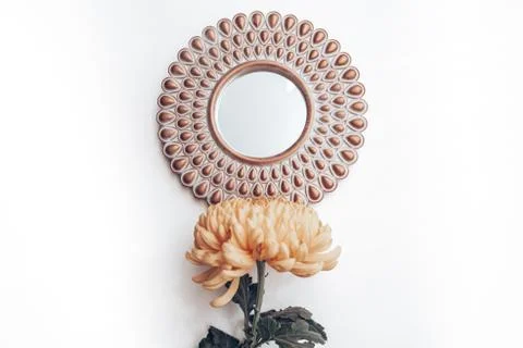 Decorative mirror and yellow flower on a white wall. home decor Stock Photos