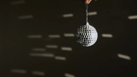 Decorative mirror ball with silvery reflections rotating on a dark background. Stock Footage 256652502