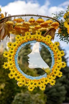 A decorative mirror cut in the shape of a woman's face, within a circle flowers, Stock Photos