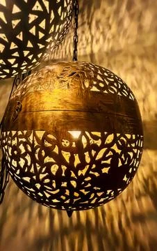 Decorative Moroccan style lanterns casting intricate shadows on wall indoors Stock Photos