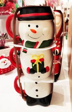 Decorative multicolored ceramic mug in the form of  snowman in the shop window Stock Photos
