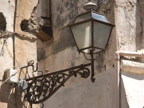 Decorative old lantern on a crumbling wall of a dilapidated building, rustic Fotos de archivo