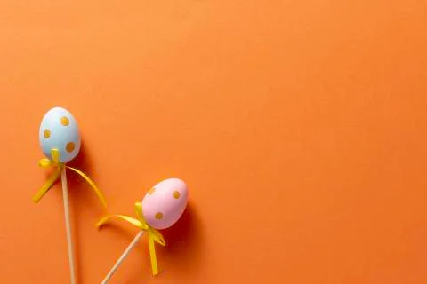 Decorative ornaments in the form of Easter eggs on an orange background. Copy Stock Photos