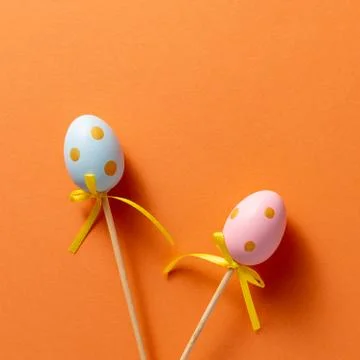 Decorative ornaments in the form of Easter eggs on an orange background. Copy Stock Photos