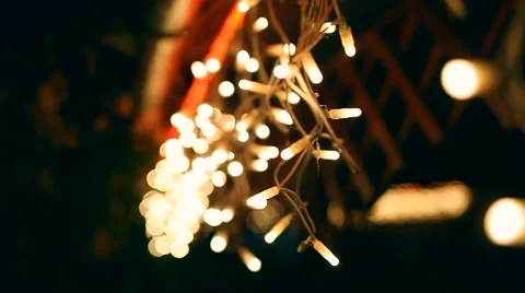 Decorative outdoor string lights hanging on tree in the garden at night time Stock Footage 64764394