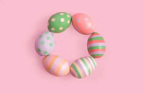 Decorative painted Easter eggs lie in a ring on a pink background Stock Photos