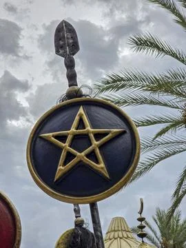 Decorative parade standard with black shield and gold pentagram seen among .. Stock Photos