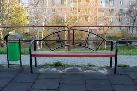 Decorative park bench with trash bin in residential courtyard Foto stock