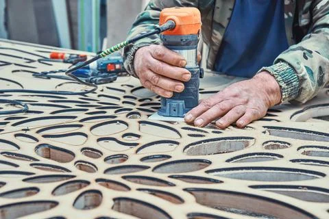 Decorative partition wall with floral pattern. Carpenter milling holes in MDF Stock Photos