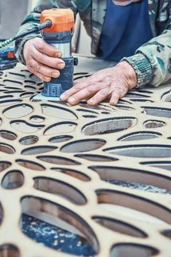 Decorative partition wall with floral pattern. Carpenter milling holes in MDF Stock Photos